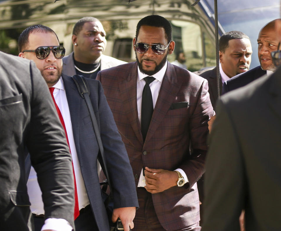 FILE - In this June 26, 2019, file photo, R&B singer R. Kelly, center, arrives at the Leighton Criminal Court building for an arraignment on sex-related felonies in Chicago. Kelly, who was arrested in Chicago on July 11, 2019 on a federal grand jury indictment listing 13 counts including sex crimes and obstruction of justice, was ordered held without bond on Tuesday, July 16. (AP Photo/Amr Alfiky, File)