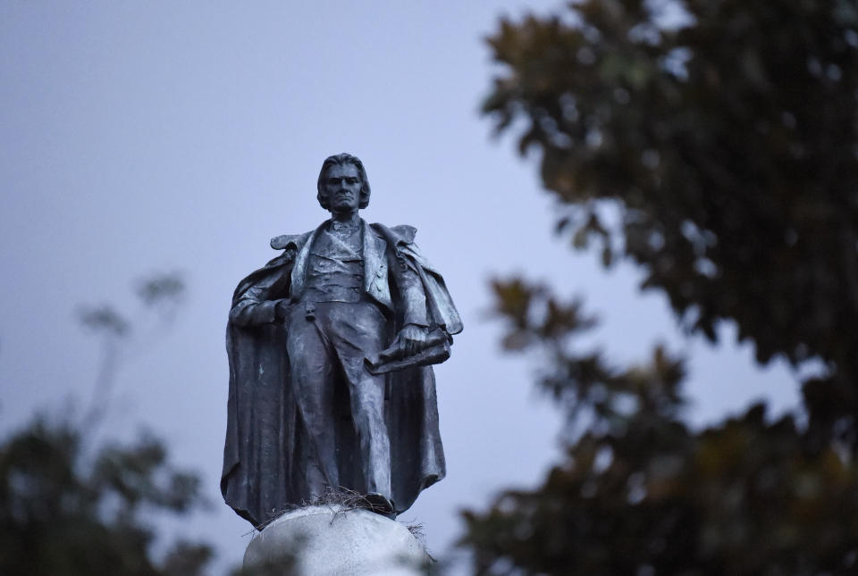 A 100-foot monument to former U.S. vice president and slavery advocate John C. Calhoun towers over a downtown square Tuesday, June 23, 2020, in Charleston, S.C. Officials in Charleston voted unanimously Tuesday to remove the statue from a downtown square, the latest in a wave of actions arising from protests against racism and police brutality against African Americans. (AP Photo/Meg Kinnard)