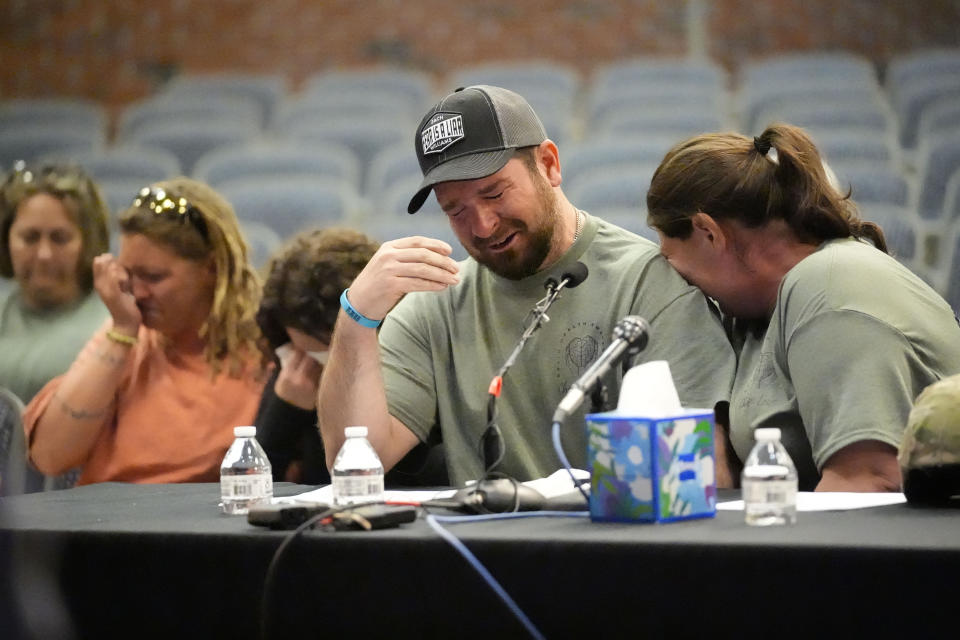 James Herling pauses his testimony while recalling the moment he realized the shooter was his brother-in-law, Robert Card, while testifying, Thursday, May 16, 2024, in Augusta, Maine, during a hearing of the independent commission investigating the law enforcement response to the mass shooting in Lewiston, Maine. Nicole Herling, sister of the shooter, cries on her husband's shoulder. (AP Photo/Robert F. Bukaty)