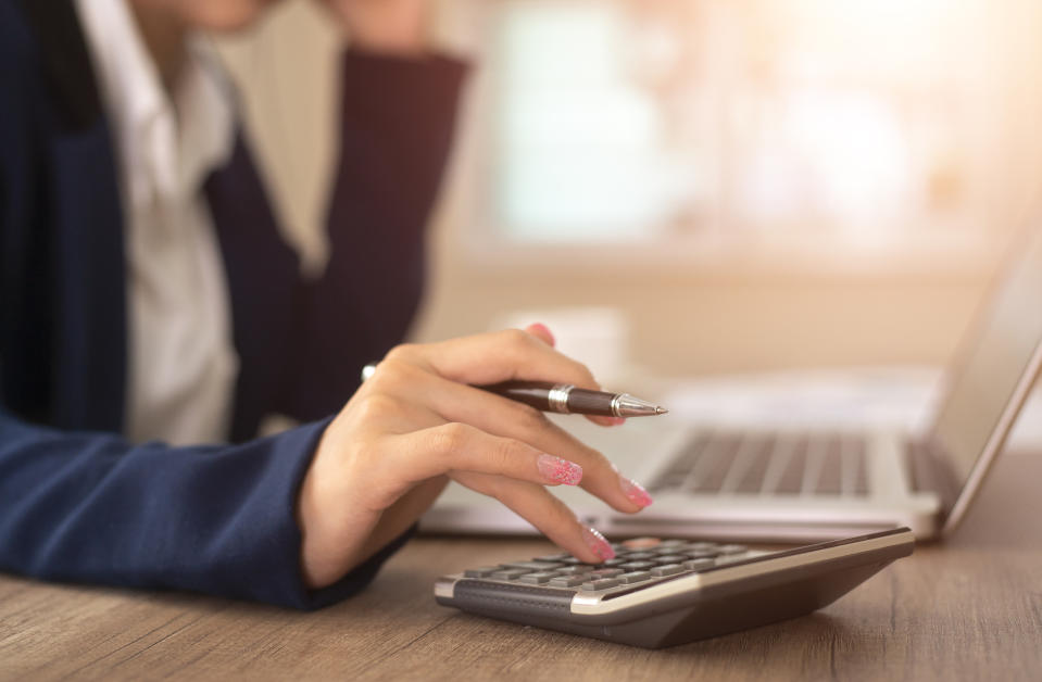 woman working with calculator, business document and laptop computer notebook