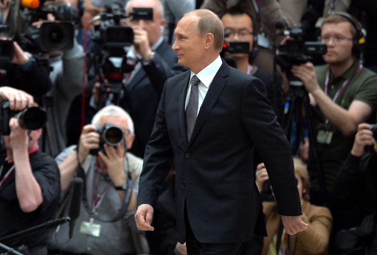 Russian President Vladimir Putin walks past journalists shortly after his annual televised phone-in with the nation in central Moscow on April 16, 2015