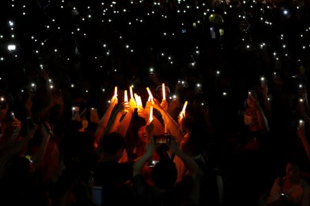 People hold up glowing sticks and mobile phones during the Mid-Autumn Festival, in Sha Tin, Hong Kong