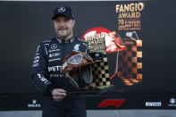 Mercedes driver Valtteri Bottas, of Finland, poses with the Fangio award after coming in first in the qualifying run of the Formula One Mexico Grand Prix auto race at the Hermanos Rodriguez racetrack in Mexico City, Saturday, Nov. 6, 2021. (Francisco Guasco, Pool Photo via AP)