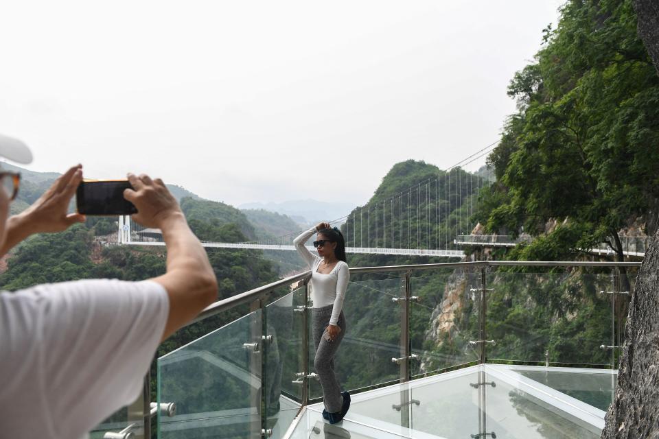 people take pictures on the Bach Long glass bridge in the Moc Chau district in Vietnam's Son La province