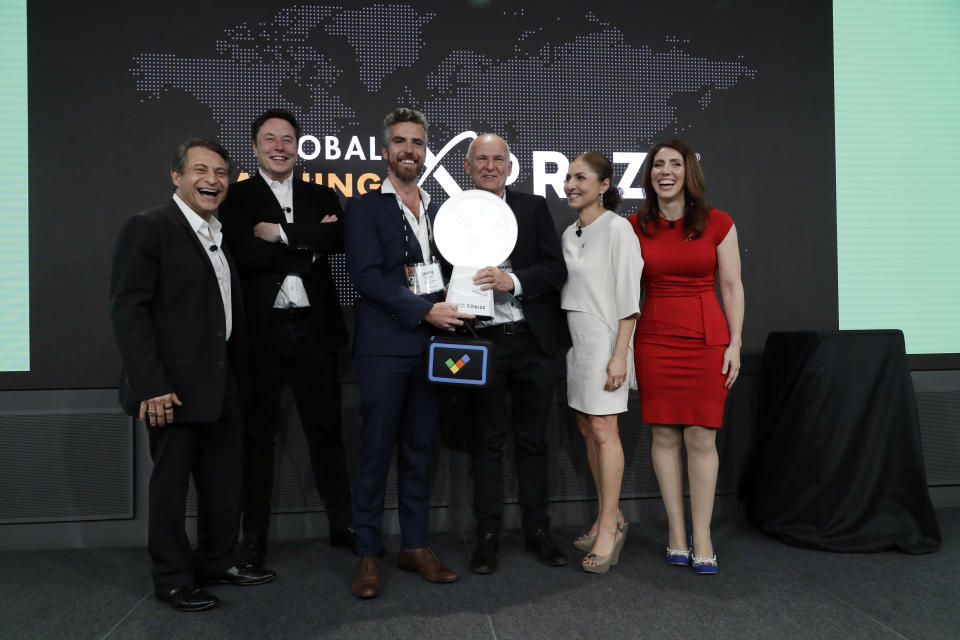 onebillion CEO Andrew Ashe, third from right, and CTO Jamie Stuart, third from left, receive the XPRIZE Children's Literacy award from XPRIZE Founder and Executive Chairman, Peter Diamandis, far left, Telsa CEO Elon Musk, second from left, XPRIZE CEO Anousheh Ansari, second from right, and Executive Director Emily Church, far right, Wednesday, May 15, 2019, in Los Angeles. The Berkeley-based Kitkit School and London's onebillion educational nonprofit were declared co-winners of the XPRIZE For Global Learning at a presentation Wednesday night and will share a $10 million award. (AP Photo/Marcio Jose Sanchez)