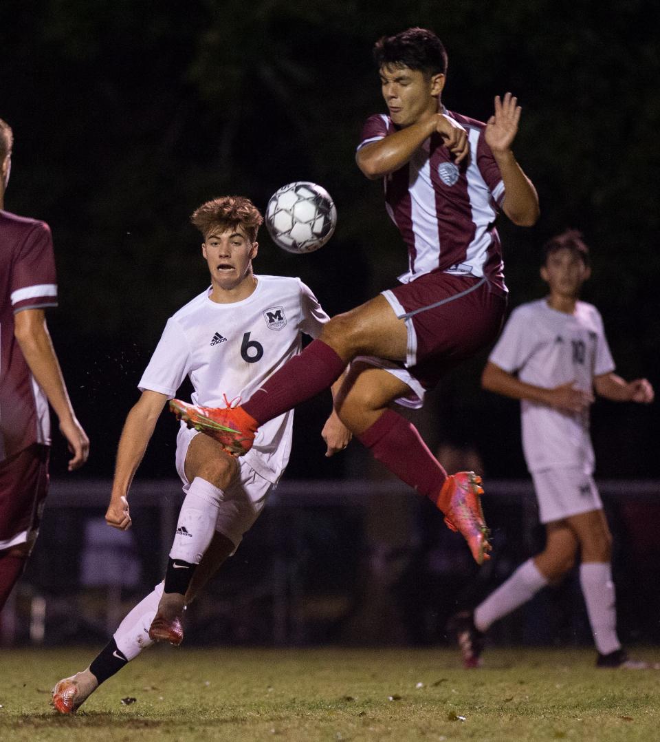 Madisonville's Logan Terry (6) kicks the ball forward while Henderson's Justin Sanchez (7) attempts to block as the Henderson County Colonels face the Madisonville-North Hopkins Maroons in the 2nd Region Soccer Tournament semifinals at the Stadium of Champions in Hopkinsville, Ky., Wednesday evening, Oct. 13, 2021.