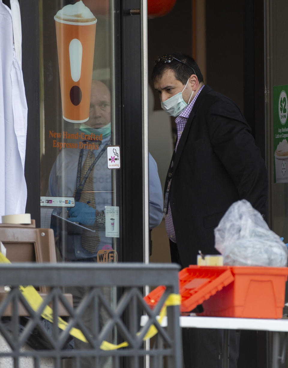 Houston Police homicide detectives investigate the scene of a fatal shooting at the Dunkin' Donuts on the 5800 block of Memorial Drive Friday, Feb. 15, 2019, in Houston. (Godofredo A. Vasquez/Houston Chronicle via AP)