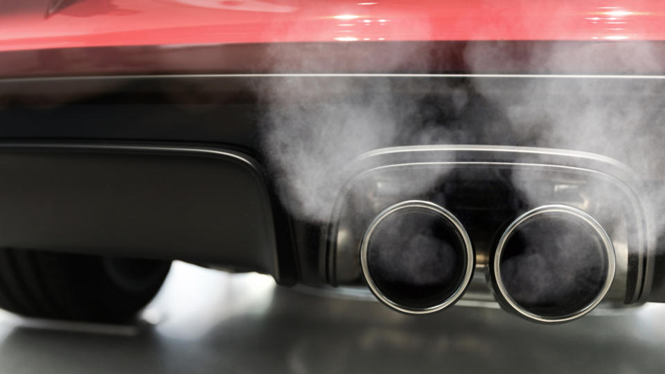 A close up of a car's smoking exhaust pipes.