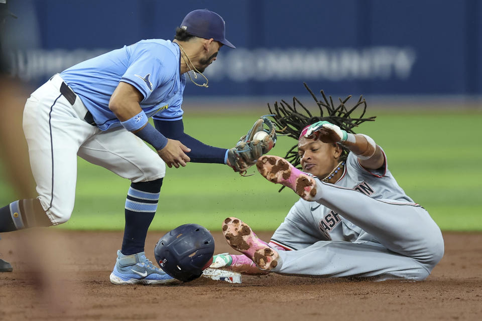 Washington Nationals' CJ Abrams, right, steals second base past a tag by Tampa Bay Rays' Jose Caballero during the third inning of a baseball game Sunday, June 30, 2024, in St. Petersburg, Fla. (AP Photo/Mike Carlson)