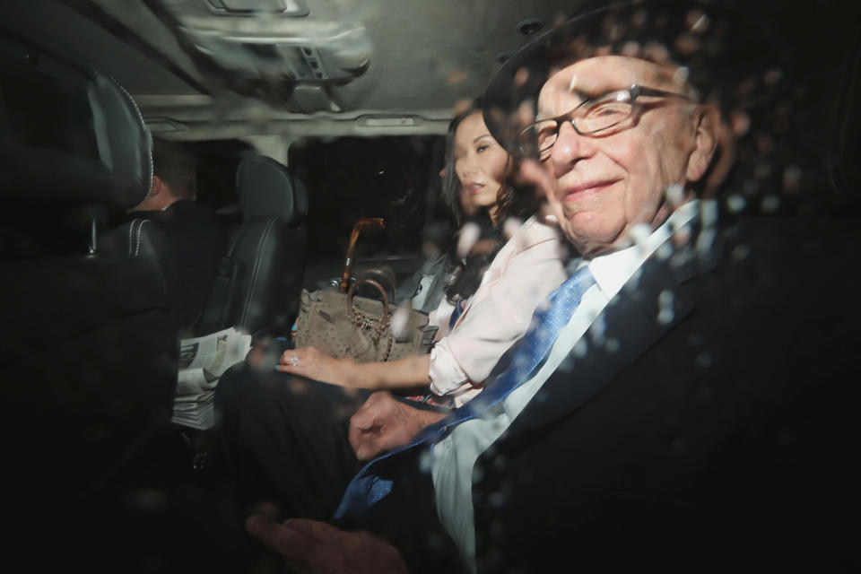 News Corp. chairman Rupert Murdoch, right, and his wife Wendi Deng sit in the back of a car as they are driven to the Leveson inquiry at the High Court in London, Thursday, April 26, 2012.  (AP Photo/Matt Dunham)