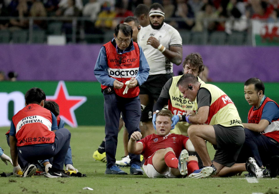 Wales' Dan Biggar is assisted after he was injured during the Rugby World Cup Pool D game at Oita Stadium between Wales and Fiji in Oita, Japan, Wednesday, Oct. 9, 2019. (AP Photo/Aaron Favila)