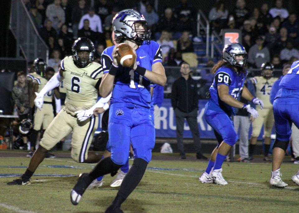 Bartram Trail quarterback Riley Trujillo (11) scrambles away from Buchholz defender Gavin Hill (6) during the teams' Oct. 21 game.