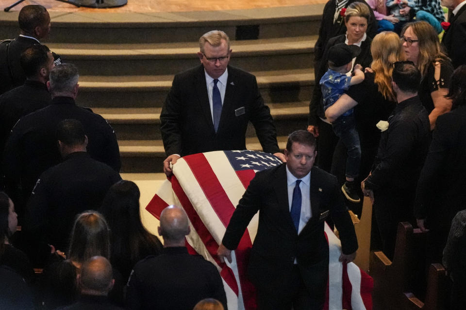 The casket is carried out of the church during a memorial service for Officer Joshua Eyer, Friday, May 3, 2024, in Charlotte, N.C. Police in North Carolina say a shootout that killed Eyer and wounded and killed other officers began as officers approached a home to serve a felony warrant on Monday. (AP Photo/Chris Carlson)