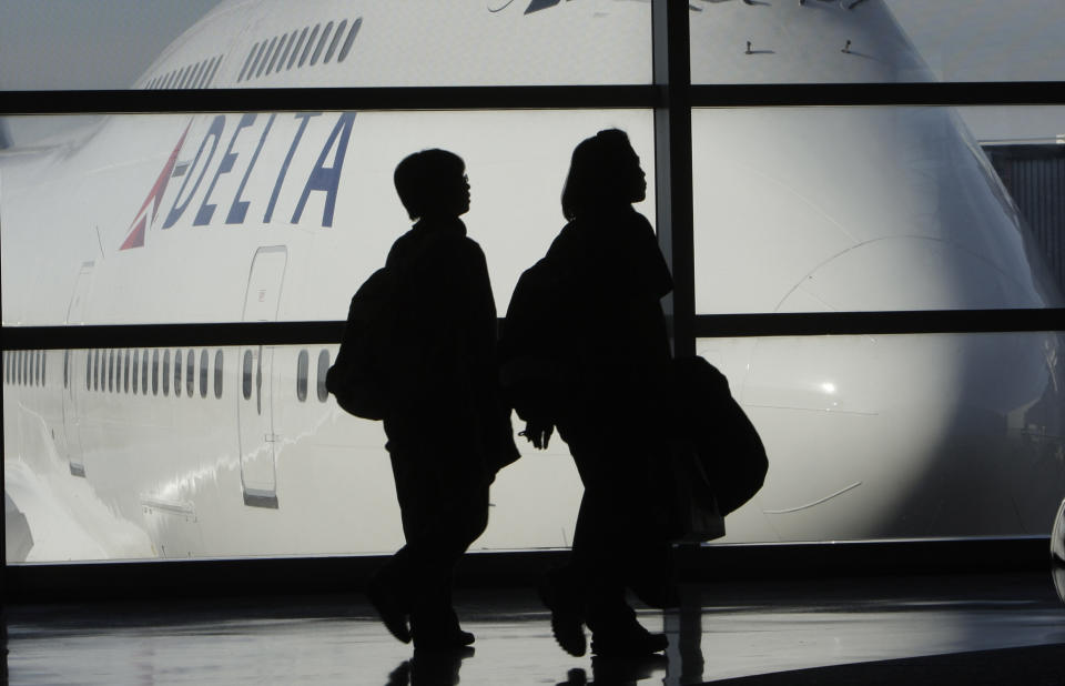 FILE - In this Jan. 21, 2010 file photo, passengers walk past a Delta Airlines 747 aircraft in McNamara Terminal at Detroit Metropolitan Wayne County Airport in Romulus, Mich. Delta Air Lines Inc. said Tuesday, April 26, 2011, raising fares should allow it to make up for the higher fuel prices that drove a $318 million loss in the first quarter.(AP Photo/Paul Sancya, file)