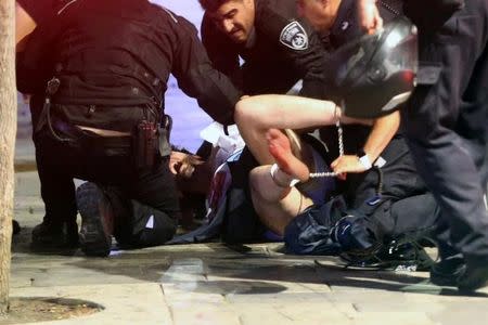 Israeli policemen arrest a suspected man following a shooting attack that took place in the center of Tel Aviv June 8, 2016. REUTERS/Stringer/Files