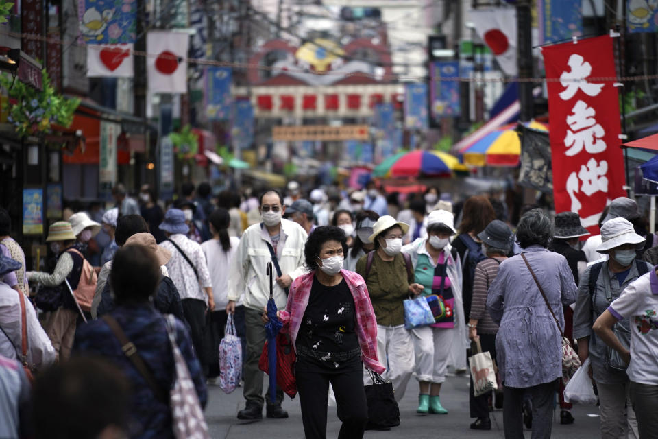 Shoppers walking in a street in Tokyo on 24 June, 2020. (PHOTO: AP)