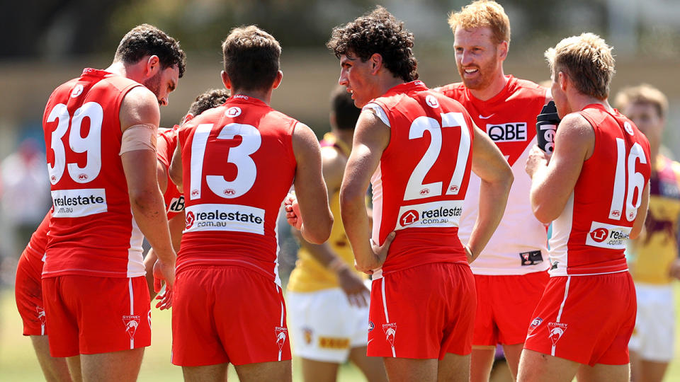 Sydney Swans players huddle up during their pre-season trial match against the Brisbane Lions.