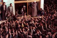 FILE - In this Feb. 2, 1979 file photo, Ayatollah Ruhollah Khomeini, center, is greeted by supporters in Tehran, Iran. Friday, Feb. 1, 2019 marks the 40th anniversary of Iran’s exiled Ayatollah Ruhollah Khomeini return to Tehran, a moment that changed the country’s history for decades to come. That revolution would spark the U.S. Embassy takeover and hostage crisis, stoking the animosity that exists between Tehran and Washington to this day. (AP Photo, File)