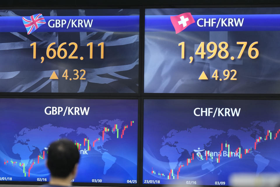 A currency trader walks by the screens showing the foreign exchange rates at a foreign exchange dealing room in Seoul, South Korea, Tuesday, April 25, 2023. Asian stocks were mixed Tuesday after Wall Street edged higher as investors awaited U.S. earnings reports and an update on economic growth.(AP Photo/Lee Jin-man)