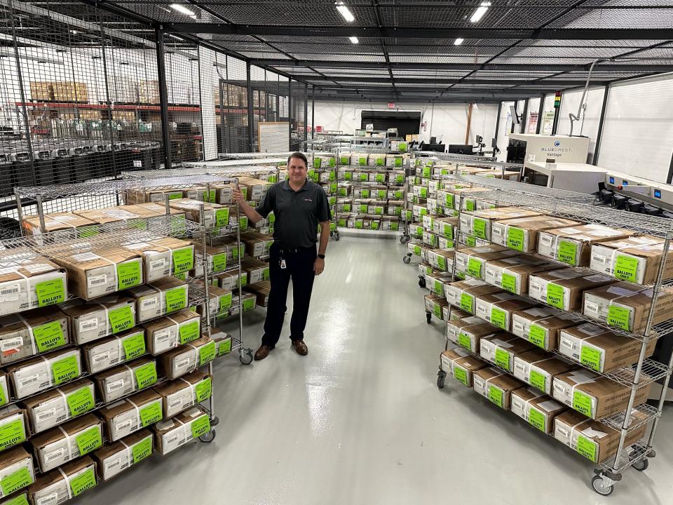 Brevard County Supervisor of Elections Tim Bobanic stands next to some of the 65,601 vote-by-mail ballots for the Aug. 20 primary before they were mailed out to voters.