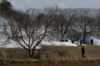 Greek soldiers and riot police officers stand amid clouds of tear gas near Turkey's Pazarkule border crossing, in Kastanies