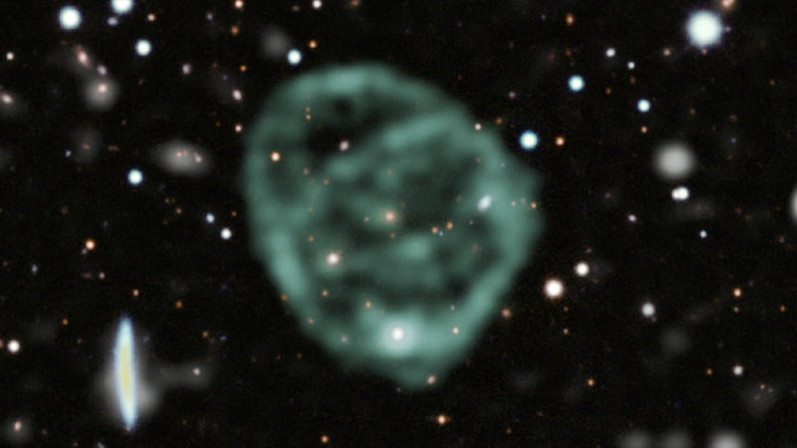  A strange blob of green circles around a galaxy in deep space. 