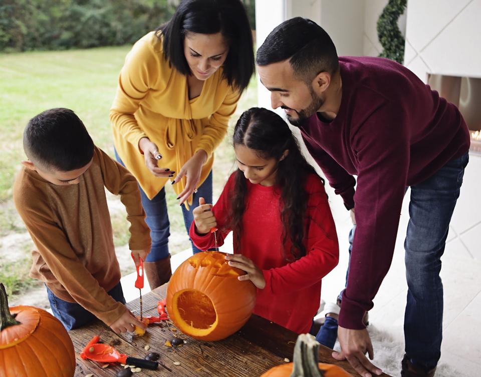 a family using the kit to carve a pumpkin