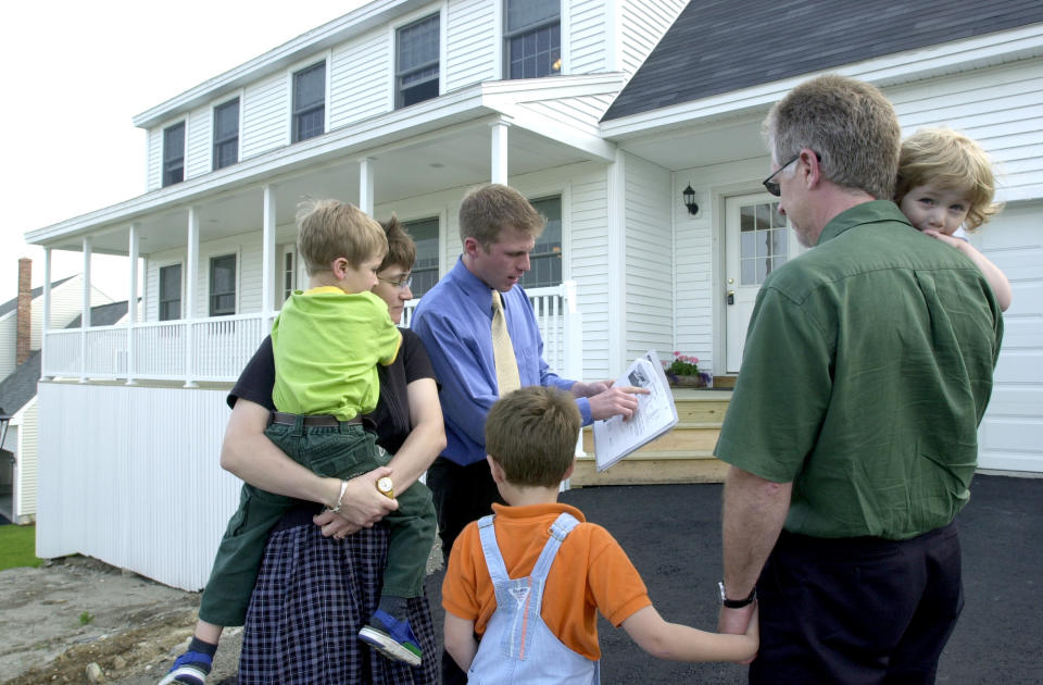Real estate agent Nick Dambrie, in blue shirt and tie, talks with prospective buyers outside #30 Gateway Commons in Gorham. The Greg Murphy family moving to the area from Ontario are looking for a home to accomodate their family of five before he starts his new job at the Maine College of Art in Portland.  (Credit: Doug Jones/Portland Press Herald via Getty Images)