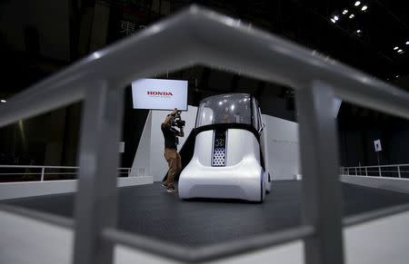 A videographer records a video of Honda Motor Co's personal mobility concept self-driving car "Wander Stand" at the 44th Tokyo Motor Show in Tokyo, Japan, October 28, 2015. REUTERS/Yuya Shino/Files