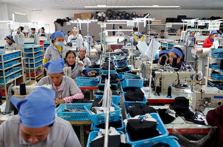 Women work on the production line at Complete Honour Footwear Industrial, a footwear factory owned by a Taiwan company, in Kampong Speu, Cambodia, July 4, 2018. REUTERS/Ann Wang