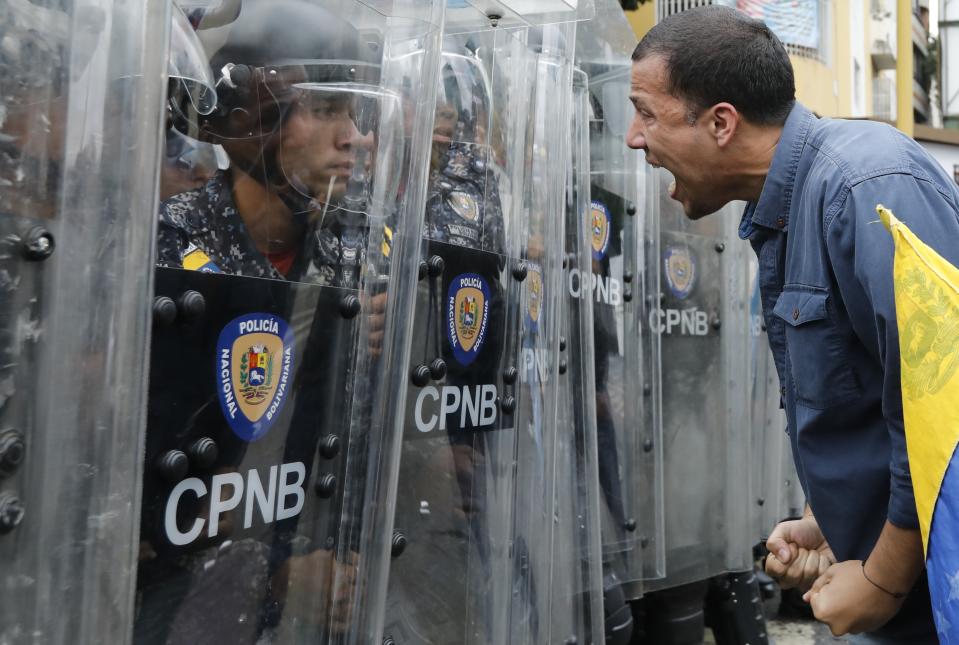 A protester yells at police blocking an opposition march in Caracas, Venezuela, Tuesday, March 10, 2020. U.S.-backed Venezuelan political leader Juan Guaido is leading a march aimed at retaking the National Assembly legislative building, which opposition lawmakers have been blocked from entering. (AP Photo/Ariana Cubillos)