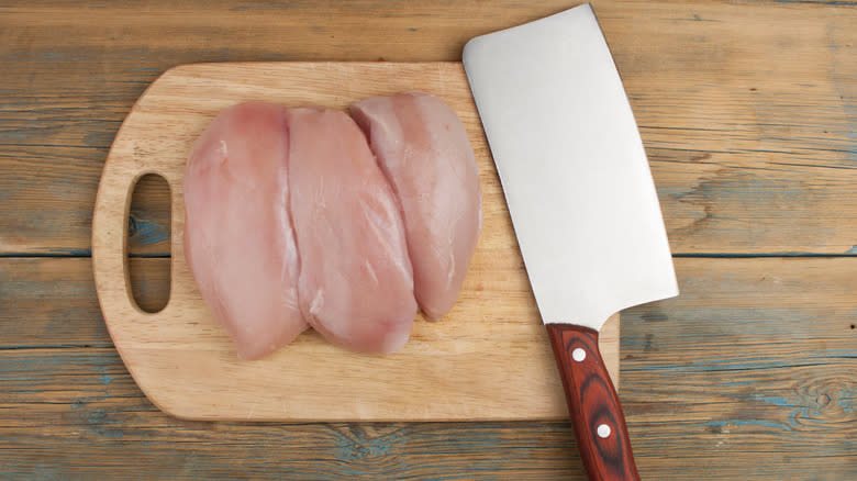 Raw chicken on wooden cutting board