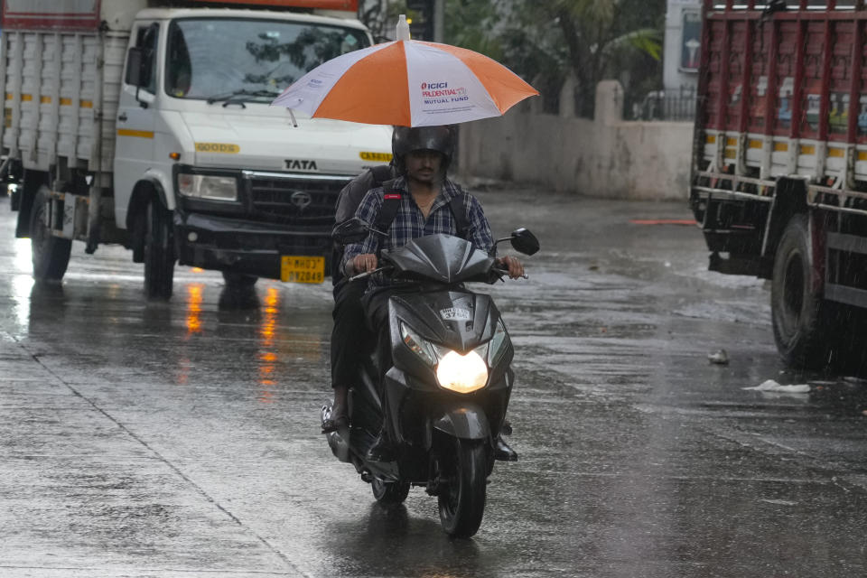 A motorist rides during a pre-monsoon thunderstorm accompanied by strong winds and rain in Mumbai, India, Monday, May 13, 2024. (AP Photo/Rafiq Maqbool)