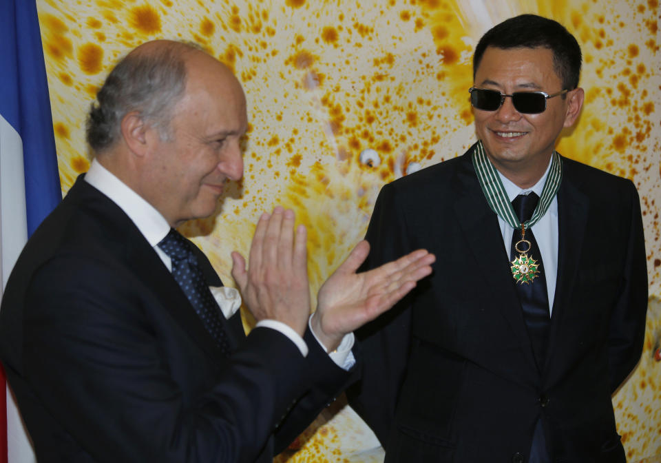 Hong Kong director Wong Kar-wai, right, smiles as he receives the Commandeur des Arts et Lettres from French Foreign Minister Laurent Fabius, in Hong Kong Sunday, May 5, 2013. Wong has been given France's highest cultural honor. (AP Photo/Vincent Yu)