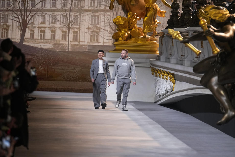 Kim Jones, right, acknowledges applause after the conclusion of the Dior fall-winter 22/23 men's collection, in Paris, Friday, Jan. 21, 2022. (AP Photo/Michel Euler)