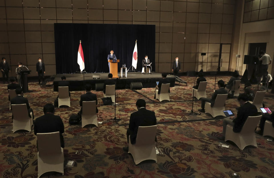 Japanese Prime Minister Yoshihide Suga speaks as members of the media sit spaced apart to maintain physical distancing during a press conference in Jakarta, Indonesia, Wednesday, Oct. 21, 2020. Suga is on a four-day visit to Vietnam and Indonesia. (AP Photo/Dita Alangkara, Pool)