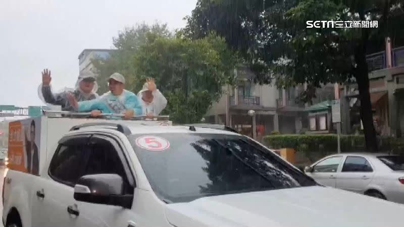 江聰淵穿上雨衣，沿路和民眾揮手拜票。