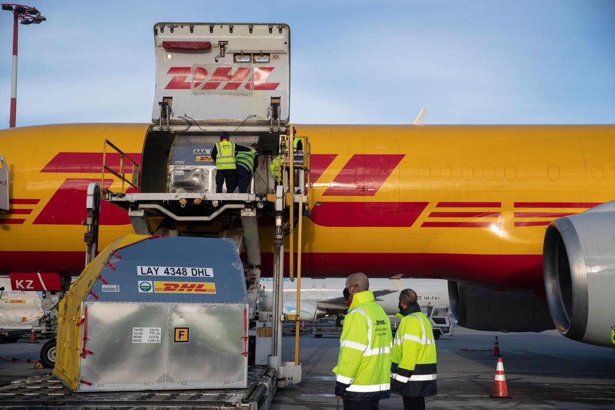 Employees of the international courier company DHL unload a shipping container with vaccines against COVID-19 at Athens' International airport in Sparta, east of Athens on Tuesday, Dec. 29, 2020.  Greece received the second batch of 83,850 doses of the Pfizer-BioNTech vaccines against COVID-19 on Tuesday.