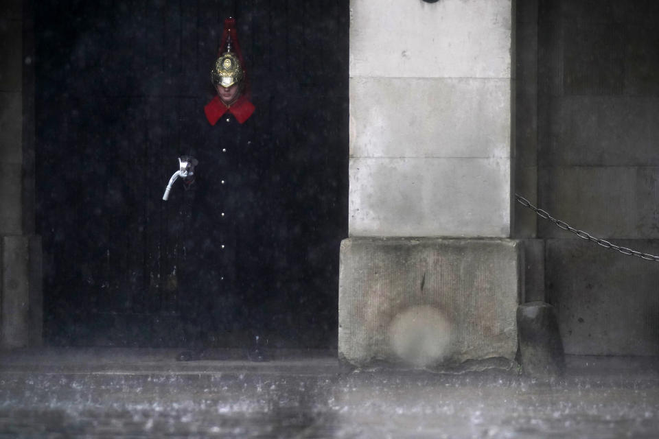 <p>A member of Household Cavalry Mounted Regiment stands in the rain at Horse Guards in Westminster as heavy rain sweeps through central London. Thunderstorms bringing lightning and torrential rain to the south are set to continue until Monday, forecasters have said. Picture date: Sunday July 25, 2021.</p>
