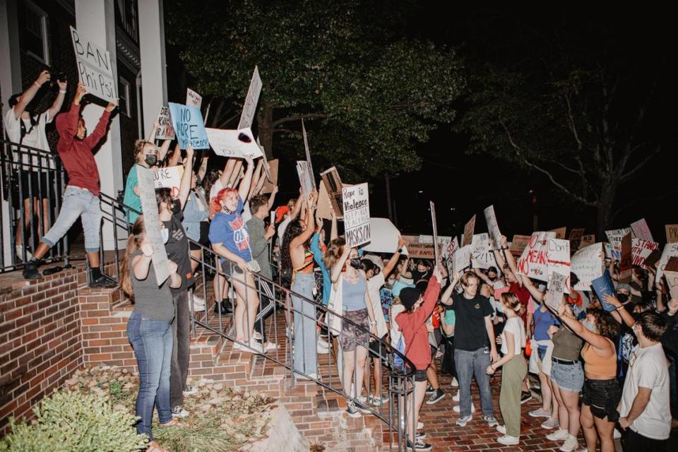 Protesters gather at the Phi Kappa Psi fraternity house Tuesday night near the University of Kansas campus in Lawrence to protest an alleged sexual assault over the weekend by a member of the fraternity.