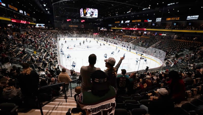 Fans watch players as they warm up prior to the Arizona Coyotes' NHL home opening hockey game against the Winnipeg Jets at the 5,000-seat Mullett Arena in Tempe, Ariz., Friday, Oct. 28, 2022.