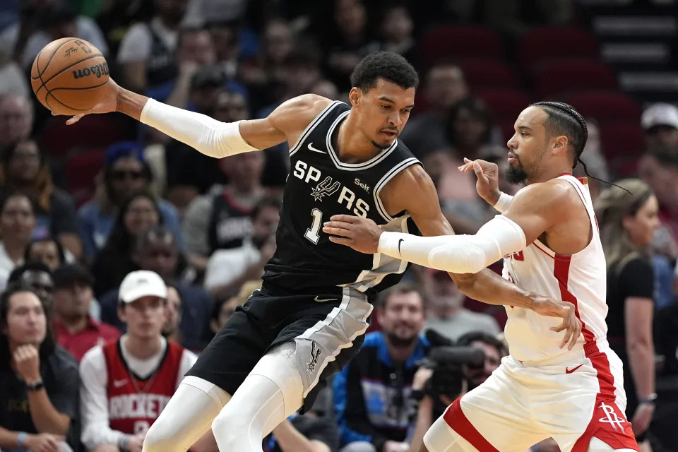 Houston Rockets' Dillon Brooks, right, defends against San Antonio Spurs' Victor Wembanyama (1) during the first half of an NBA basketball game Tuesday, March 5, 2024, in Houston. (AP Photo/David J. Phillip)