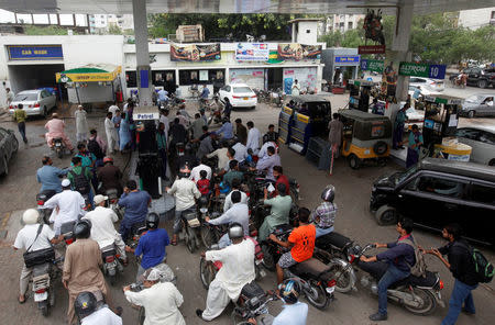 Customers gather to buy petrol at a petrol station in Karachi, Pakistan July 26, 2017. REUTERS/Akhtar Soomro