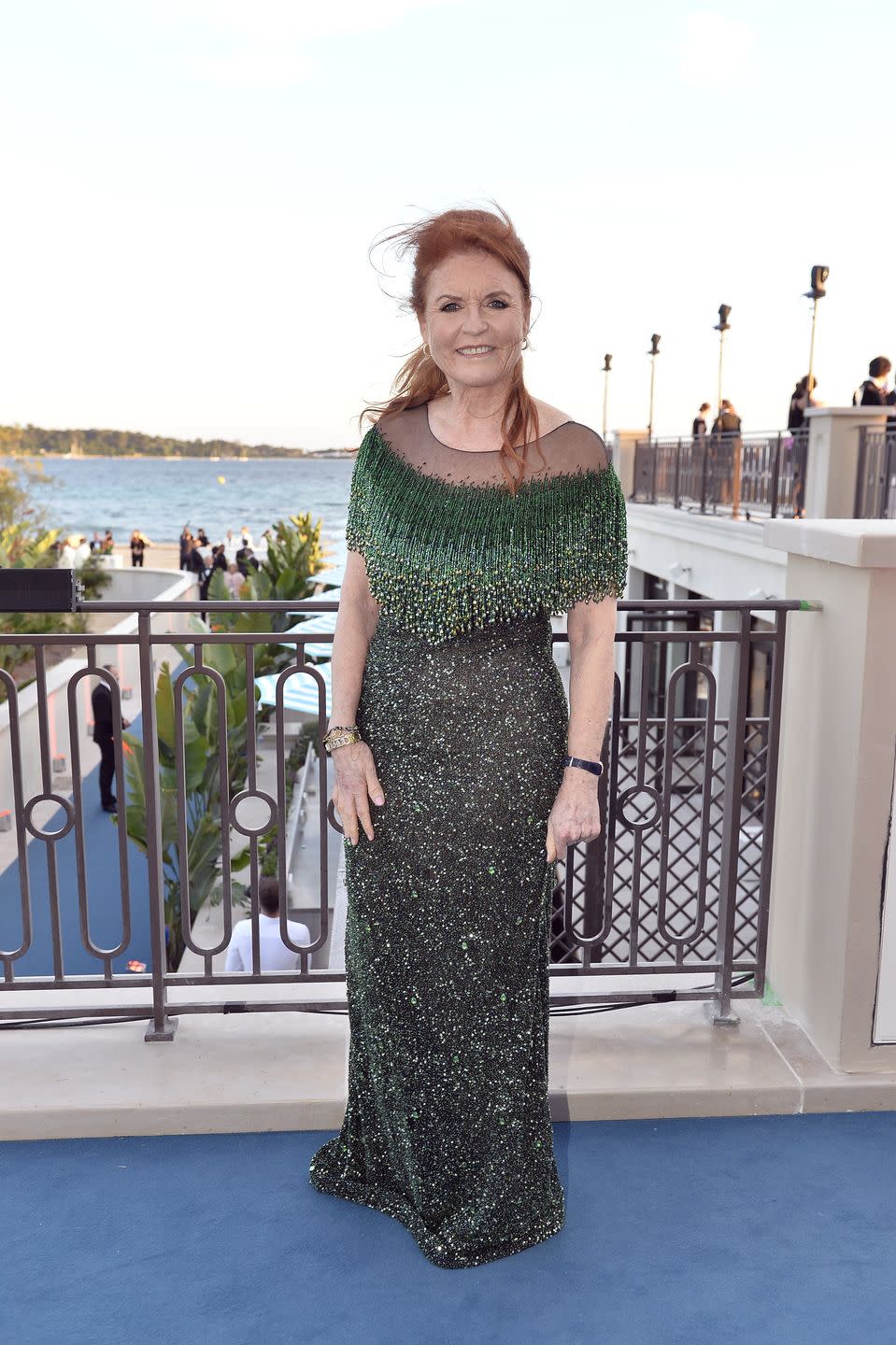 a woman in a dress standing on a balcony