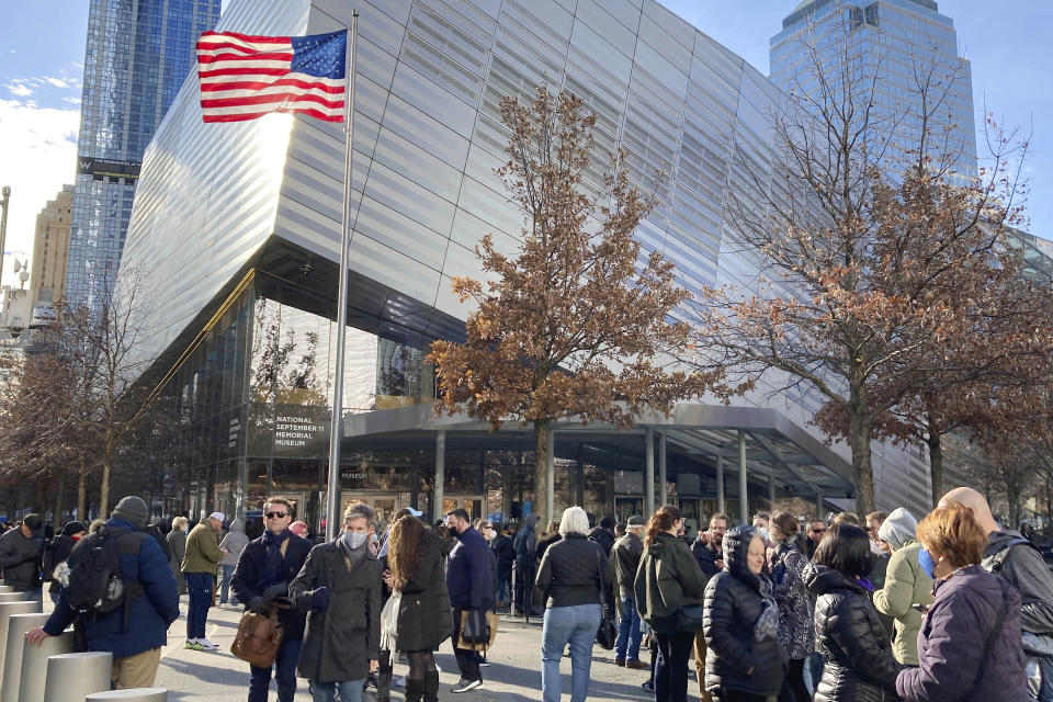 FILE — People in face masks wait in line to enter The National September 11 Memorial Museum, in New York, Dec. 3, 2021. Facing a winter surge in COVID-19 infections, New York Gov. Kathy Hochul says that masks will be required in all indoor public places unless the businesses or venues implement a vaccine requirement. (AP Photo/Ted Shaffrey, File )