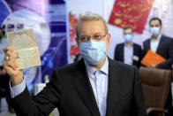 Former Iranian parliament speaker Ali Larijani shows his identification document while registering his name as a candidate for the June 18 presidential elections at elections headquarters of the Interior Ministry in Tehran, Iran, Saturday, May 15, 2021. (AP Photo/Ebrahim Noroozi)