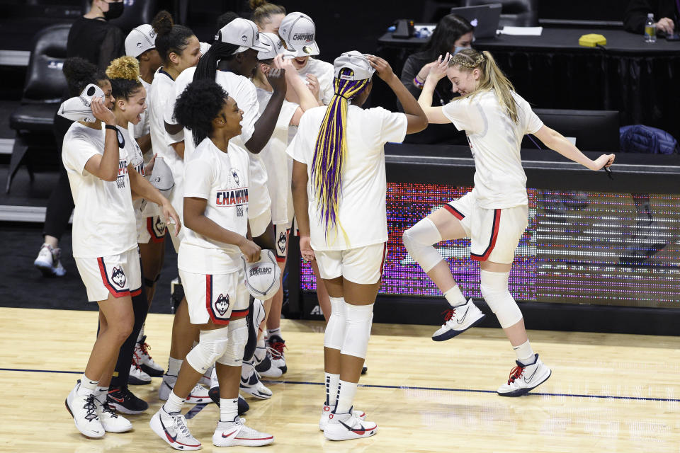 FILE - Connecticut's Paige Bueckers, right, dances over to teammates while celebrating an NCAA college basketball game win in the Big East tournament finals against Marquette at Mohegan Sun Arena in Uncasville, Conn, in this Monday, March 8, 2021, file photo. Bueckers has made The Associated Press All-America first team, announced Wednesday, March 17, 2021. (AP Photo/Jessica Hill, File)