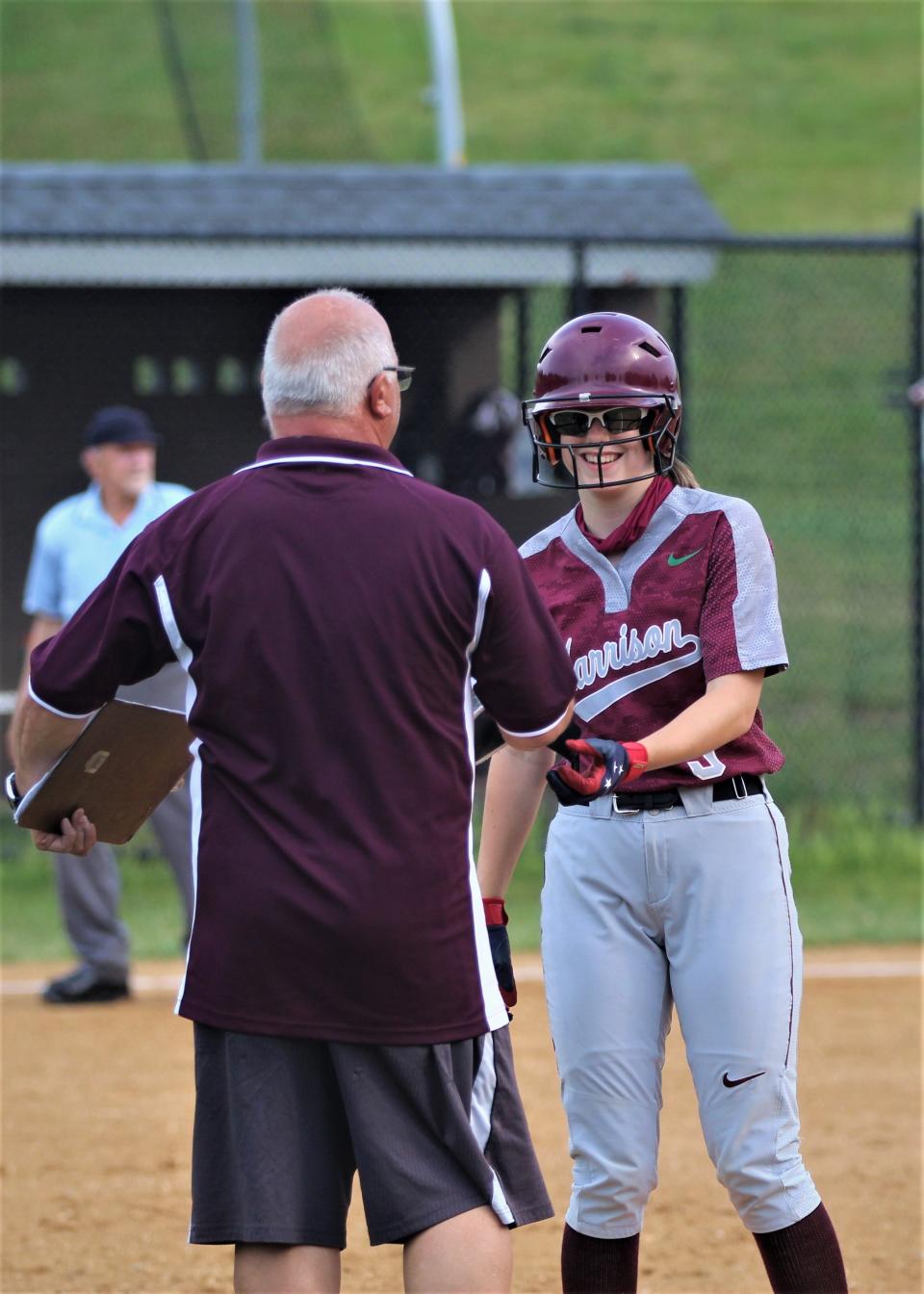 Harrison's Barbara Jo Coppola (9, right) speaks with coach Nat Acuti after getting a leadoff hit to start the game.