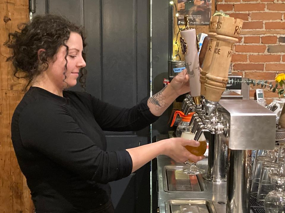 Nicki Burnham pours an Ommegang Hennepin beer Dec. 20, 2023 at The Kitchen Table restaurant in Richmond.