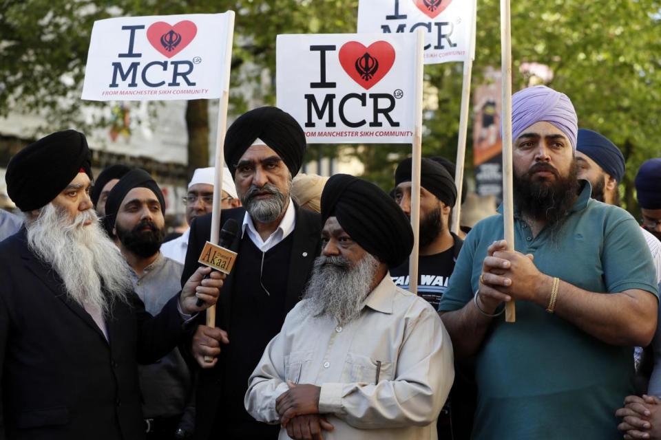 Members of the Manchester Sikh Community attend a vigil in Albert Square (AP)